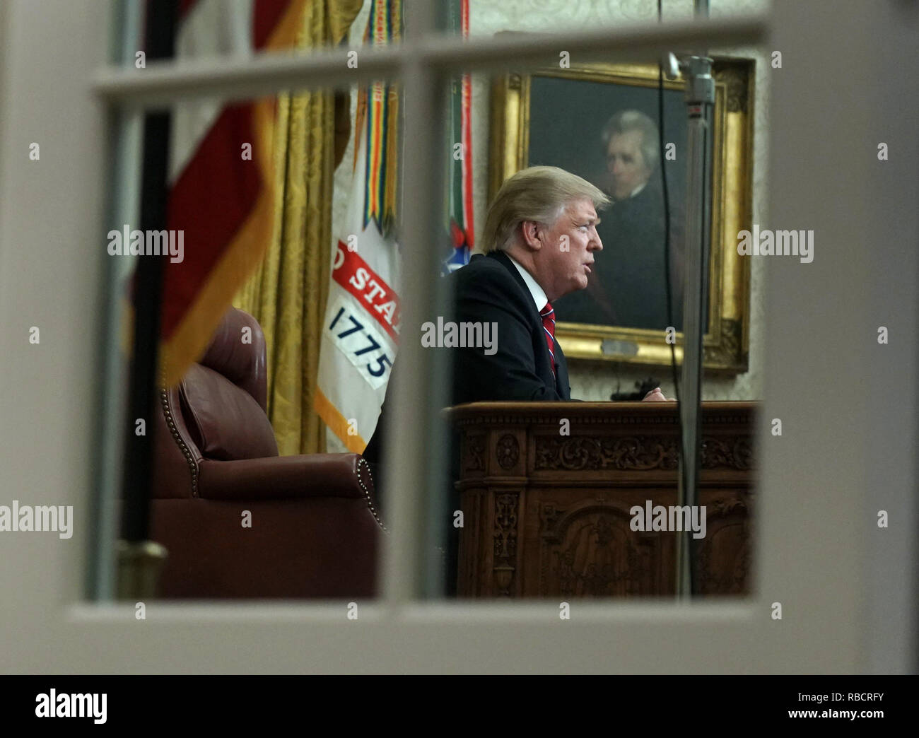 Presidente Donald Trump fornire un indirizzo teletrasmesso alla nazione dall'Ufficio Ovale della Casa Bianca di Washington il 8 gennaio 2019. Foto scattata attraverso l'Ufficio ovale di windows. Il discorso si accende il diciottesimo giorno di un governo parziale causa dello spegnimento di una controversia su una proposta di muro di confine che separa gli Stati Uniti e il Messico. Credito: Kevin Dietsch/Piscina via CNP | Utilizzo di tutto il mondo Foto Stock