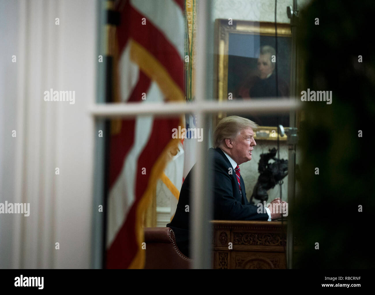 Washington, Stati Uniti d'America. 08 gen 2019. Presidente Donald Trump è visto attraverso la finestra dell'Ufficio ovale come egli offre un indirizzo primetime sul governo di spegnimento e la sua richiesta di finanziamenti per oltre 5 miliardi di dollari per un confine meridionale del muro, alla Casa Bianca di Washington, DC Credito: Kevin Dietsch/Piscina via CNP | Utilizzo di credito in tutto il mondo: dpa/Alamy Live News Foto Stock