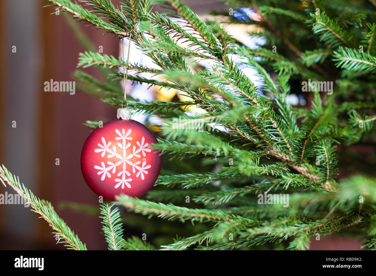 Ornamenti su verde ramoscelli di vivere albero di Natale e la TV sullo sfondo a casa indoor Foto Stock