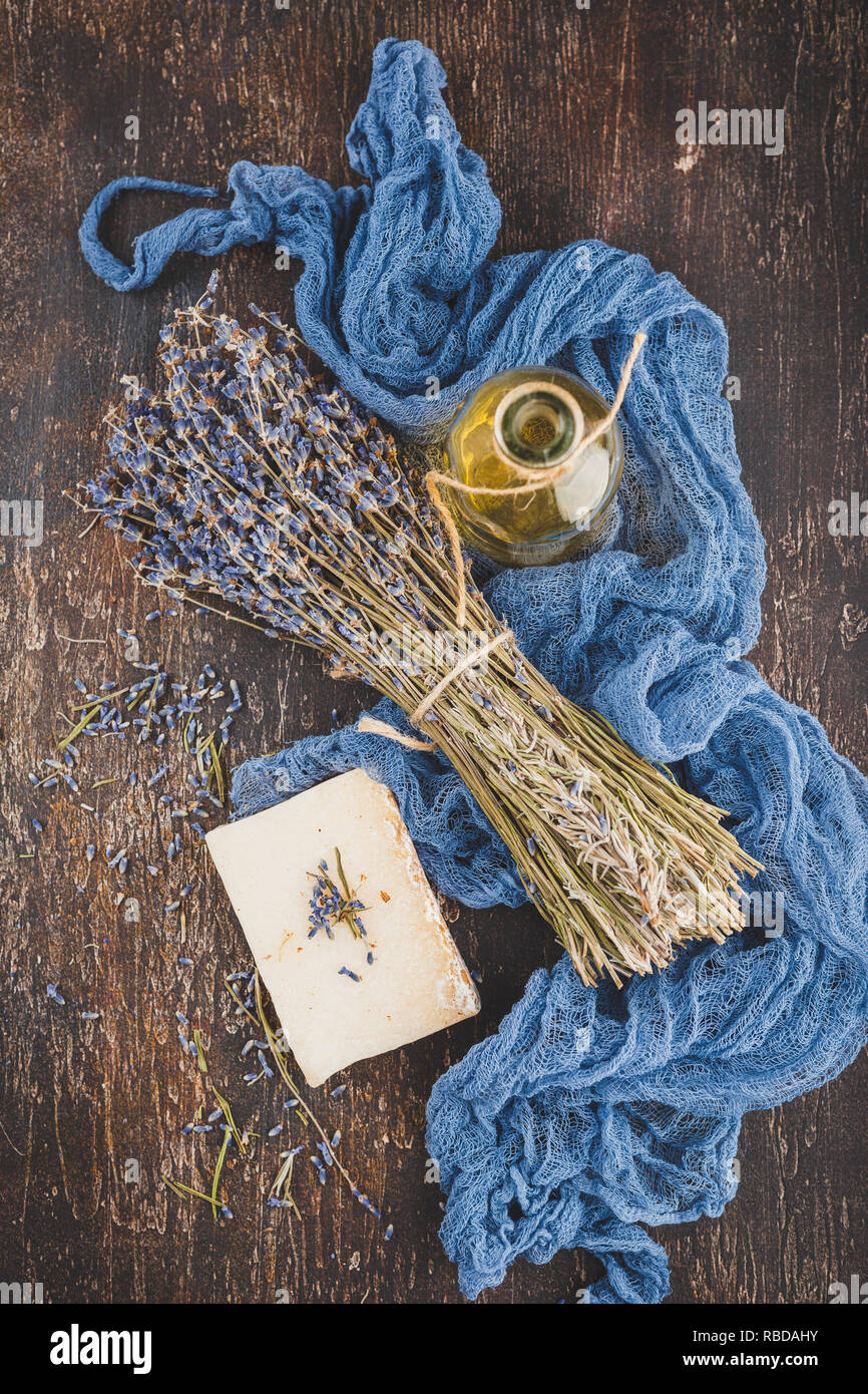 Essenziale di olio di lavanda, secco fiori di lavanda, sapone a base di erbe e di sale da bagno. Vista dall'alto. Foto Stock