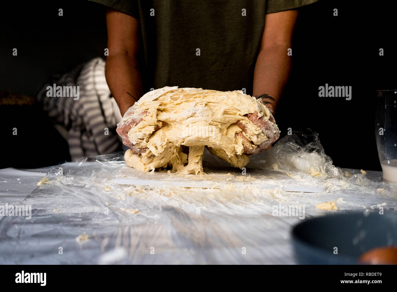 Close up della giovane donna italiana donna mani rendendo freschi fatti in casa la pasta italiana su tavola con farina Foto Stock