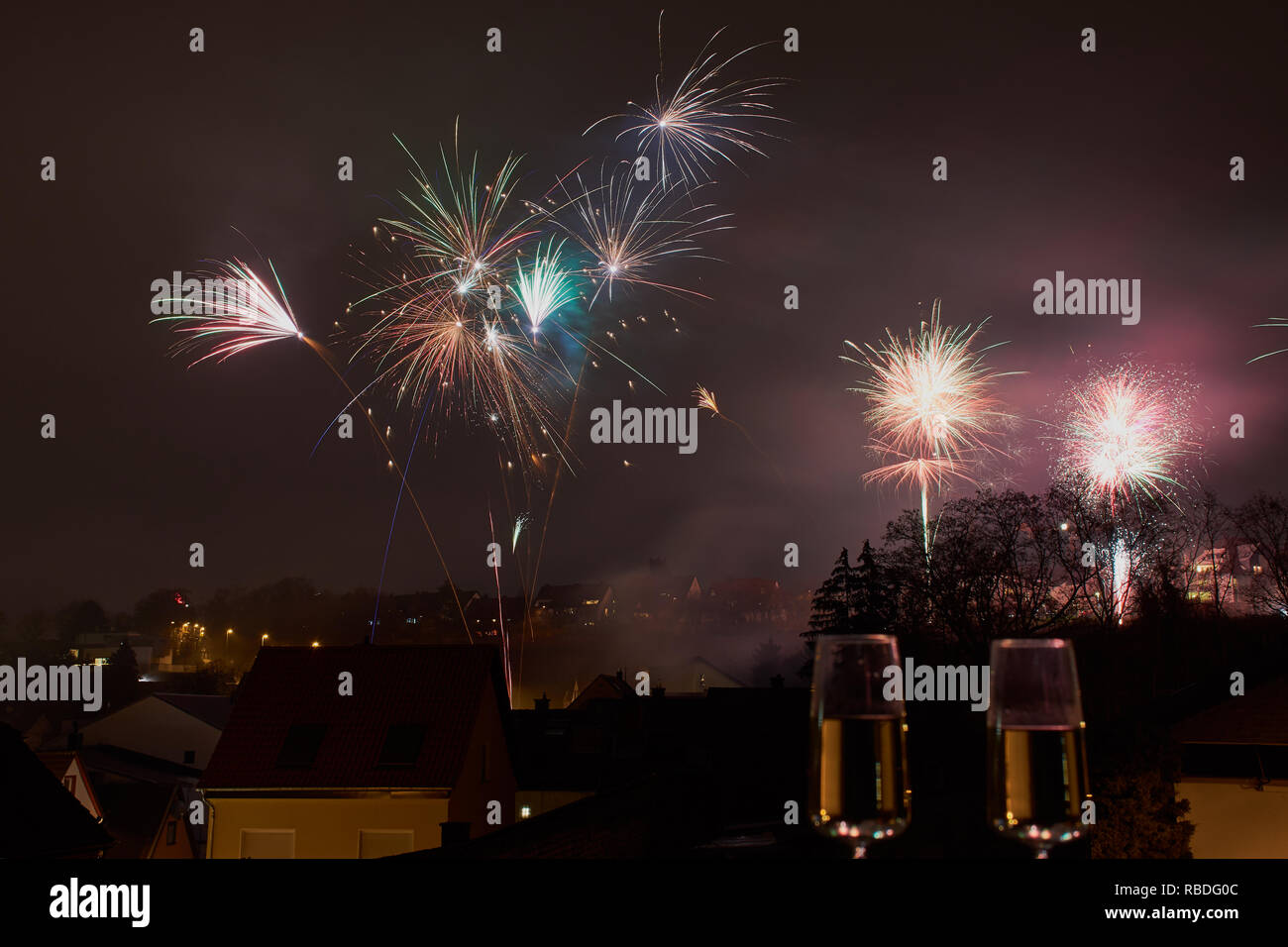 Immagine a colori con fuochi d'artificio su Mainz, Germania, due bicchieri di champagne sfumata nella parte anteriore Foto Stock