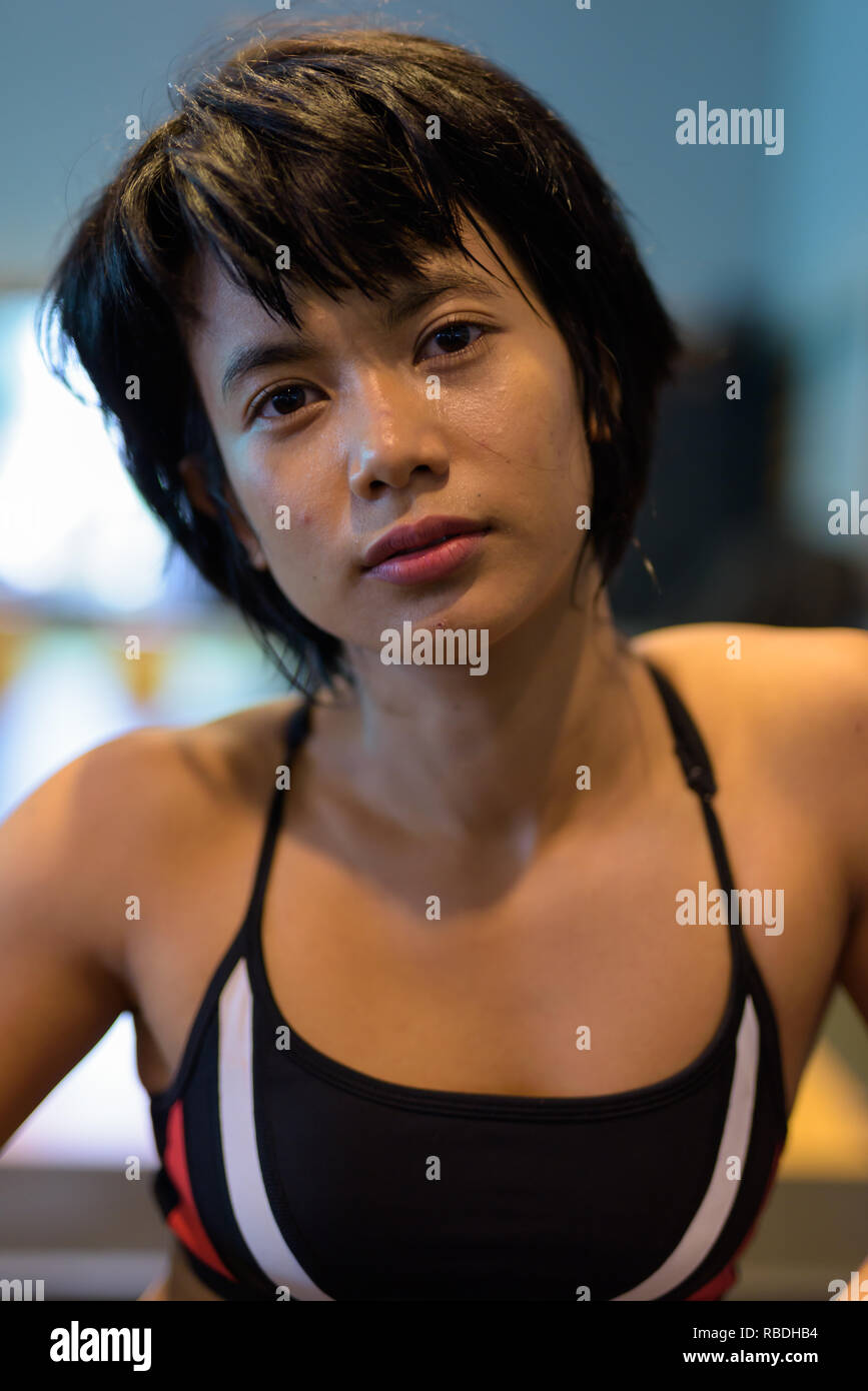 Volto del giovane bella donna asiatica che lavora fuori in palestra Foto Stock