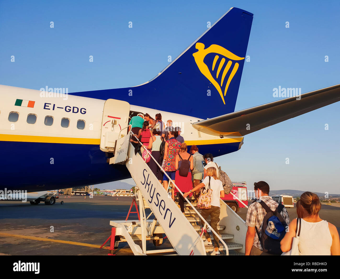 I passeggeri di bordo su asfalto dell'aeroporto di Salonicco. I viaggiatori al grembiule area dell Aeroporto Makedonia, imbarco dal ingresso posteriore di un aereo Ryanair. Foto Stock