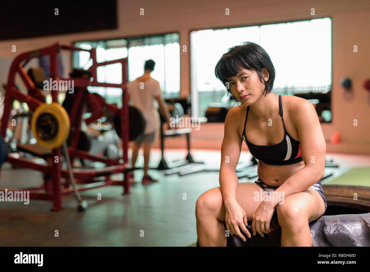 Giovane bella donna asiatica che lavora fuori in palestra Foto Stock