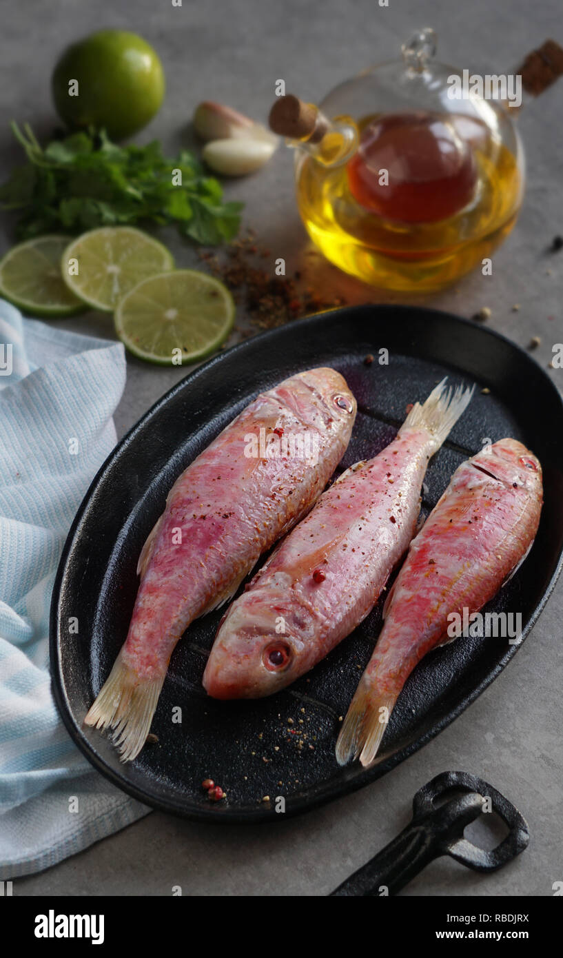 Pesce fresco triglie con calce e condimenti con olio d'oliva, aglio, spezie, calce Foto Stock