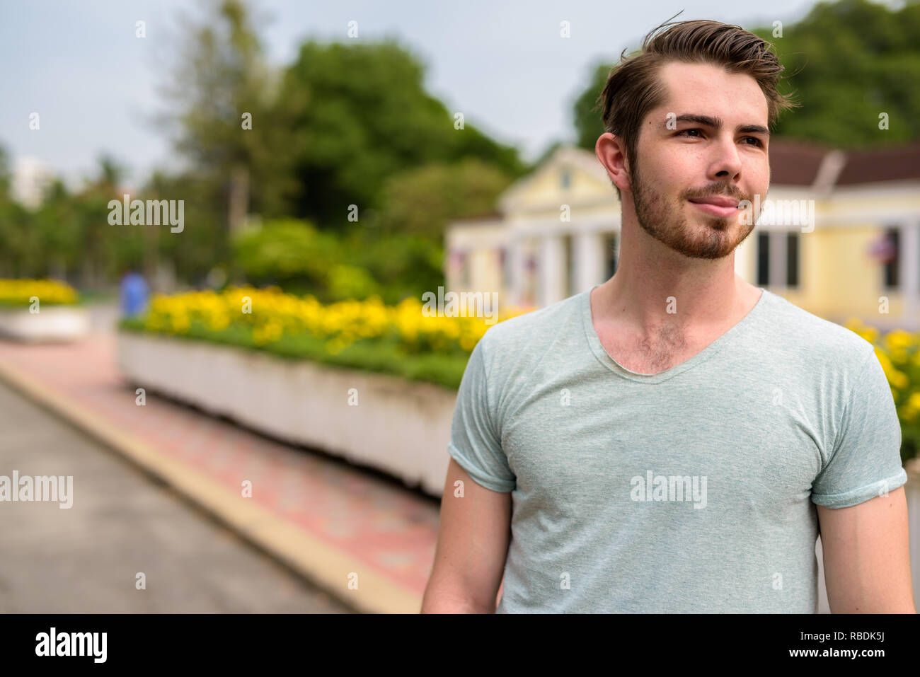 Ritratto di giovane uomo bello rilassarsi presso il parco Foto Stock