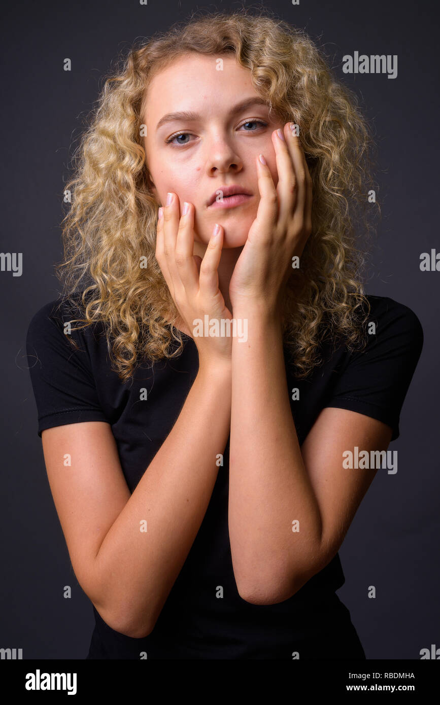 Ritratto di giovane donna bellissima con ricci capelli biondi Foto Stock