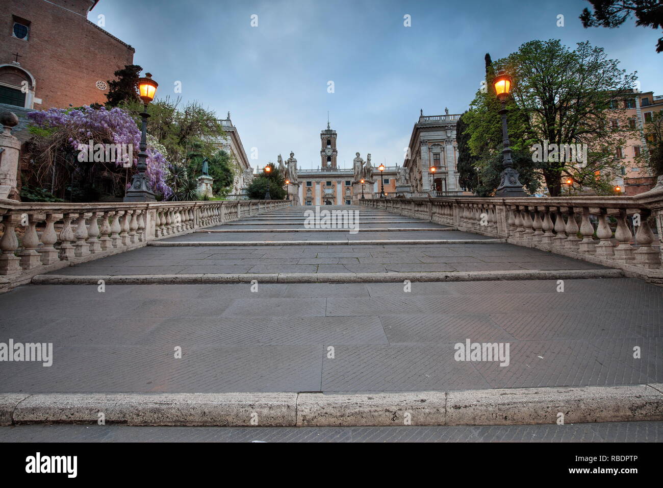 Le luci del tramonto e fiori sulle scale che portano all'antica Piazza del Campidoglio a Roma Lazio Italia Europa Foto Stock