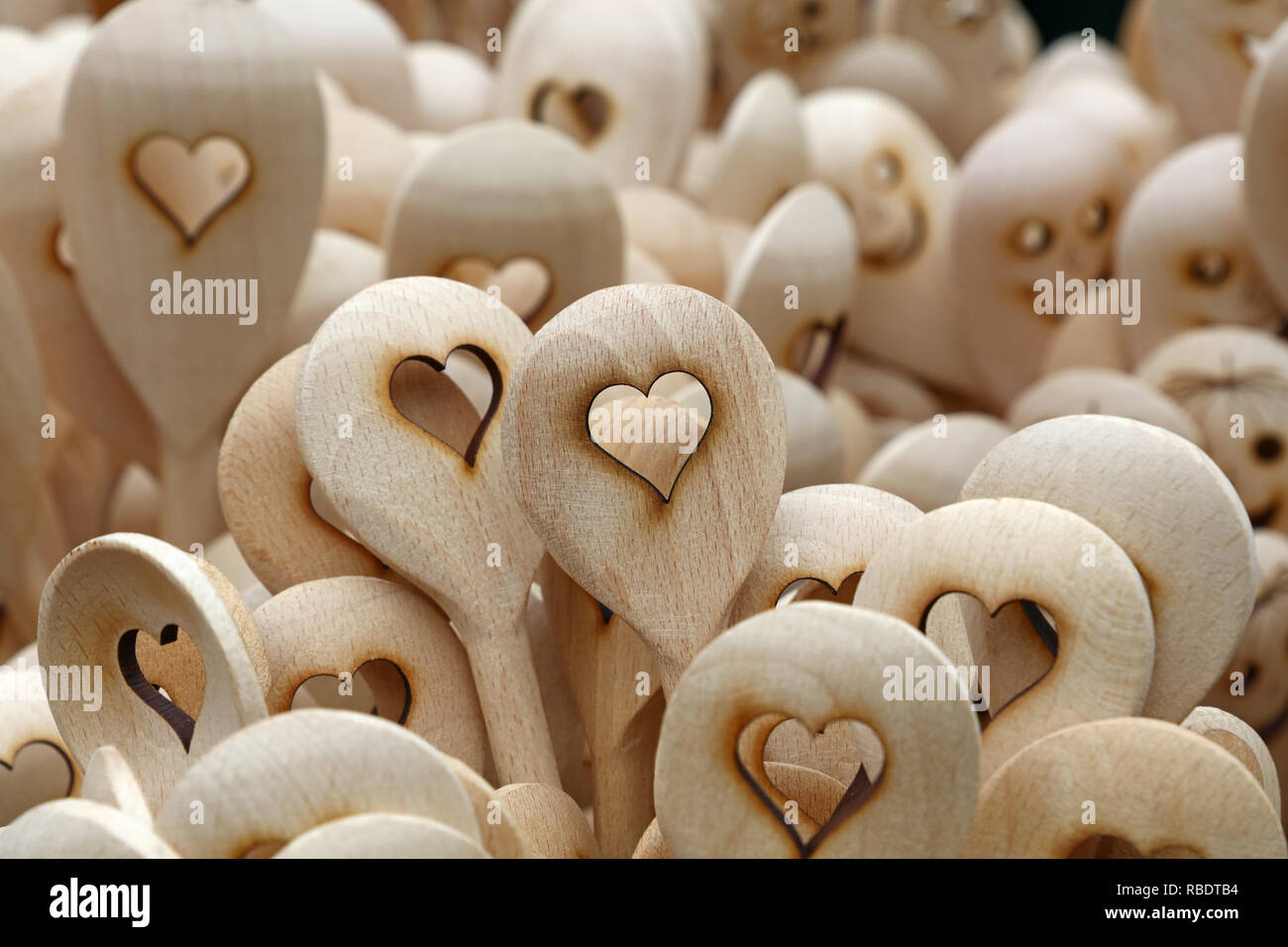 Chiudere fino a mano in legno rustico mestoli con scolpito forma di cuore al mercato retail display di stallo Foto Stock