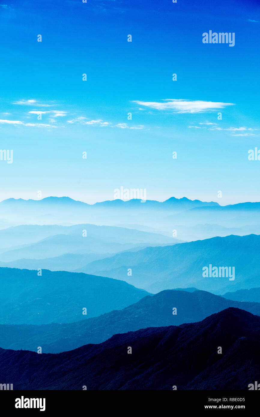 Una nebbiosa alba in Nepal con nebbia riempito di valli e colline rientranti nella distanza Foto Stock