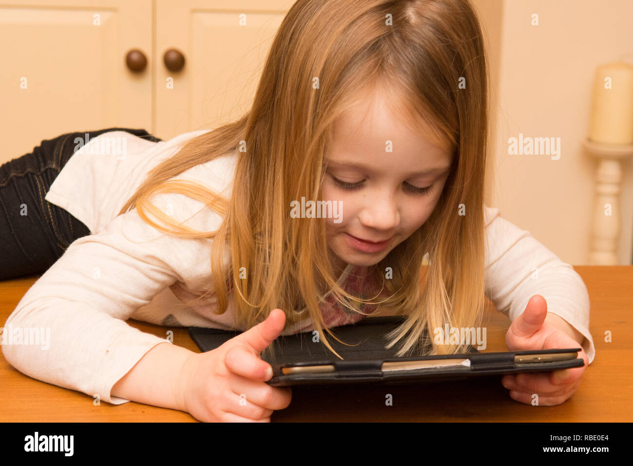 Ragazza giovane giocando con una pastiglia, dispositivo digitale, iPad schermo, bimbo di tre anni Foto Stock