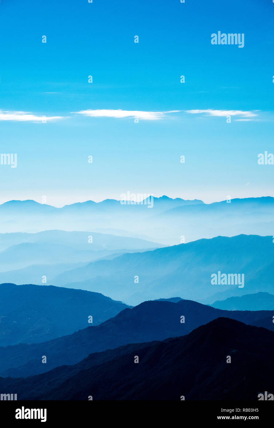 Un'alba nebbiosa nell'Himalaya del Nepal con valli e colline piene di nebbia che si allontanano in lontananza Foto Stock