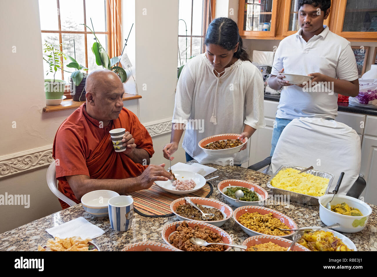 Dopo i servizi di mattina, buddisti congregants feed loro monaco con il cibo fatto in casa. A New York Vihara Buddista nel Queens, villaggio. Foto Stock