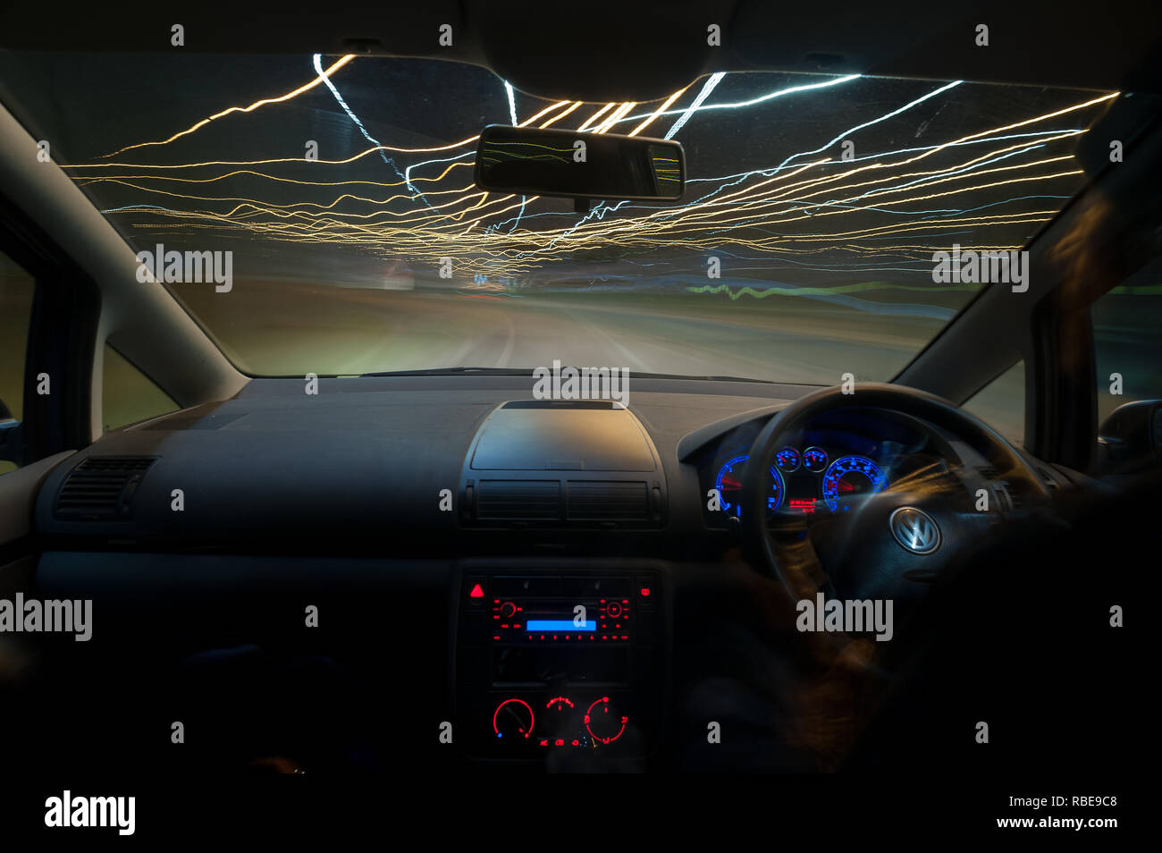 Il traffico notturno di percorsi su autostrada con fari anteriori e luci su sentieri Wrotham rotonda Foto Stock