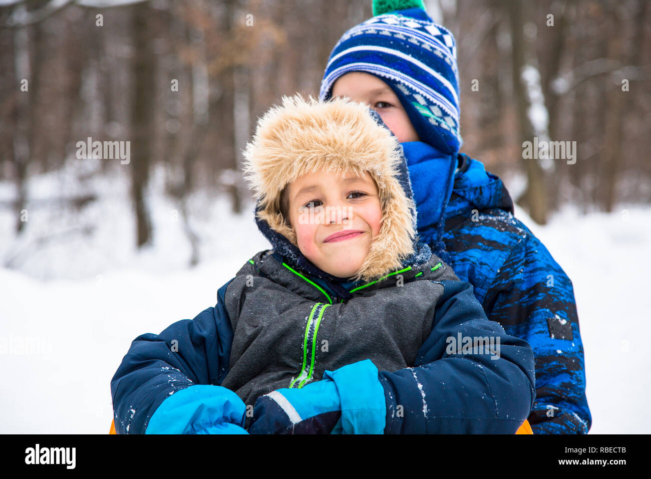 Bambino felice ragazzi giocare all'aperto in inverno abiti. Foto Stock