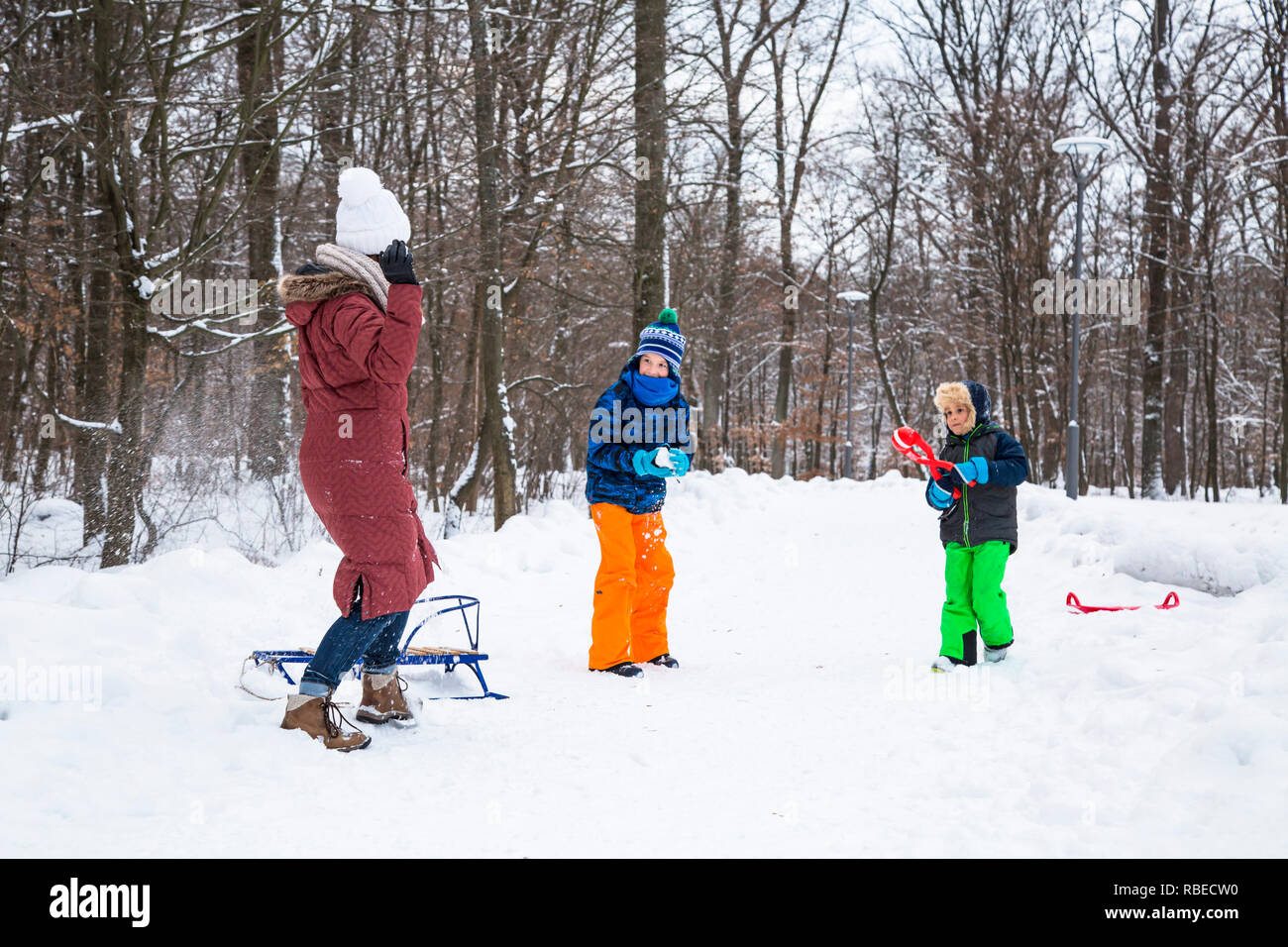 Famiglia inverno giocando snowballs all'aperto. Foto Stock