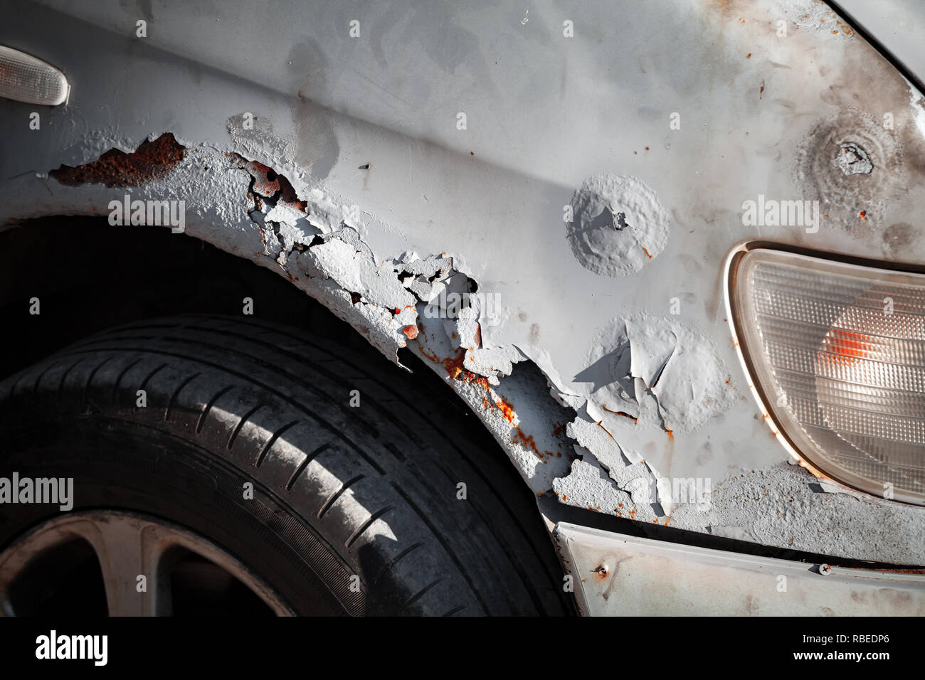 Vecchio danneggiato auto anteriore parafango con la formazione di ruggine e graffi, close-up foto Foto Stock