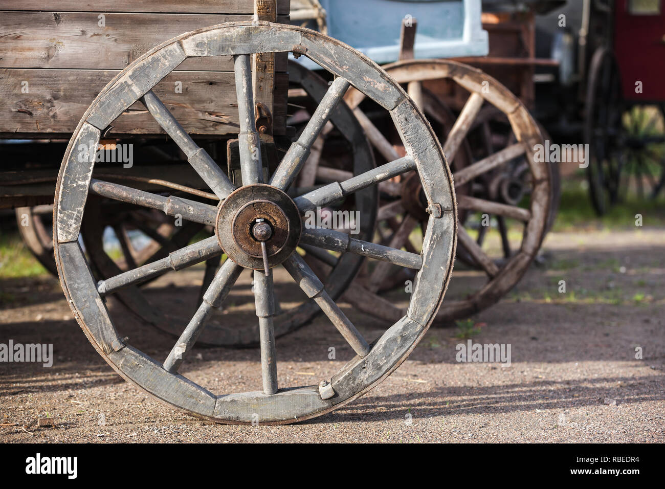 Vintage in legno ruota del carro in piedi sulla strada rurale Foto Stock
