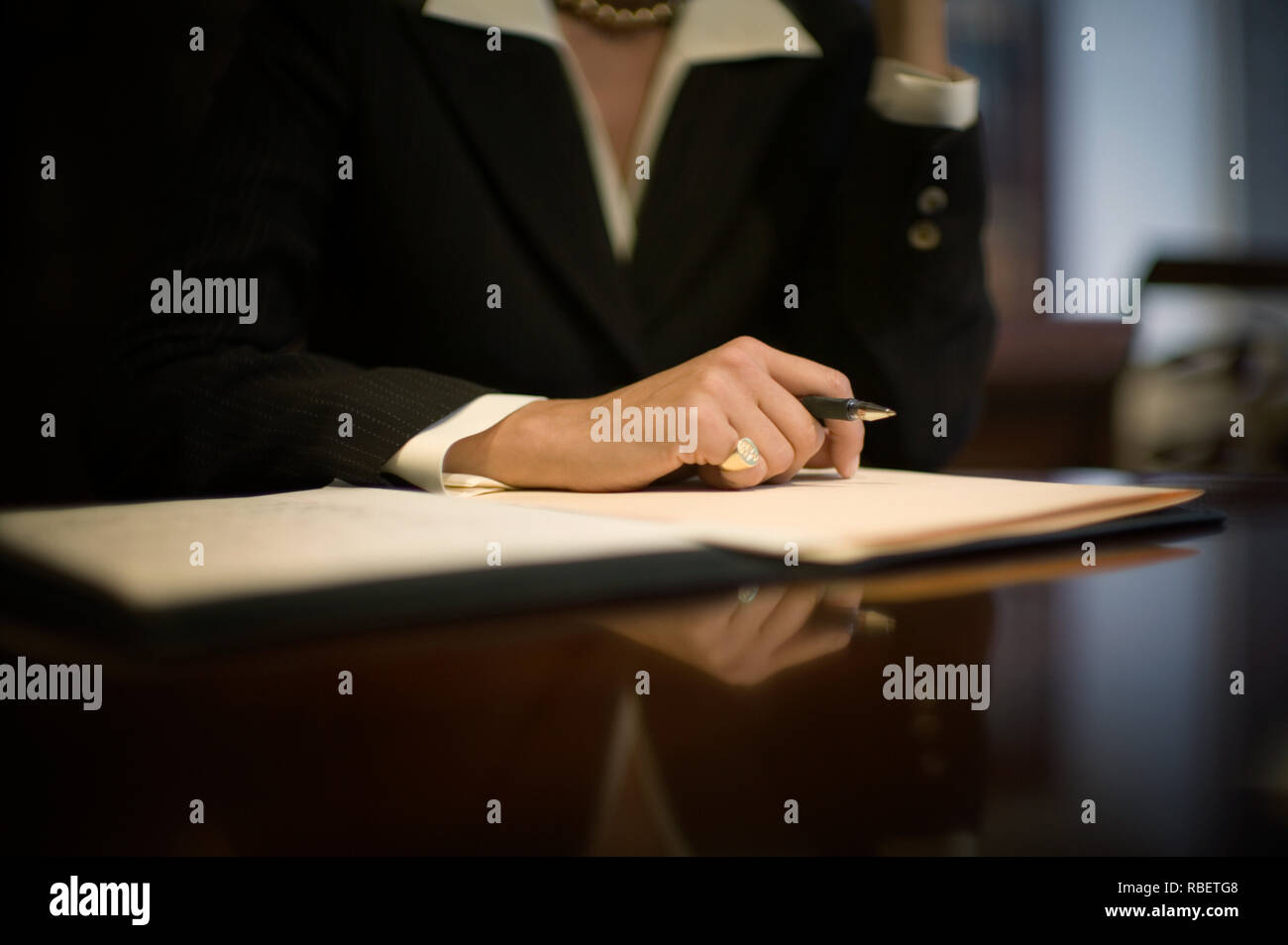 Le mani di una donna tenendo una penna sulla parte superiore della carta. Foto Stock