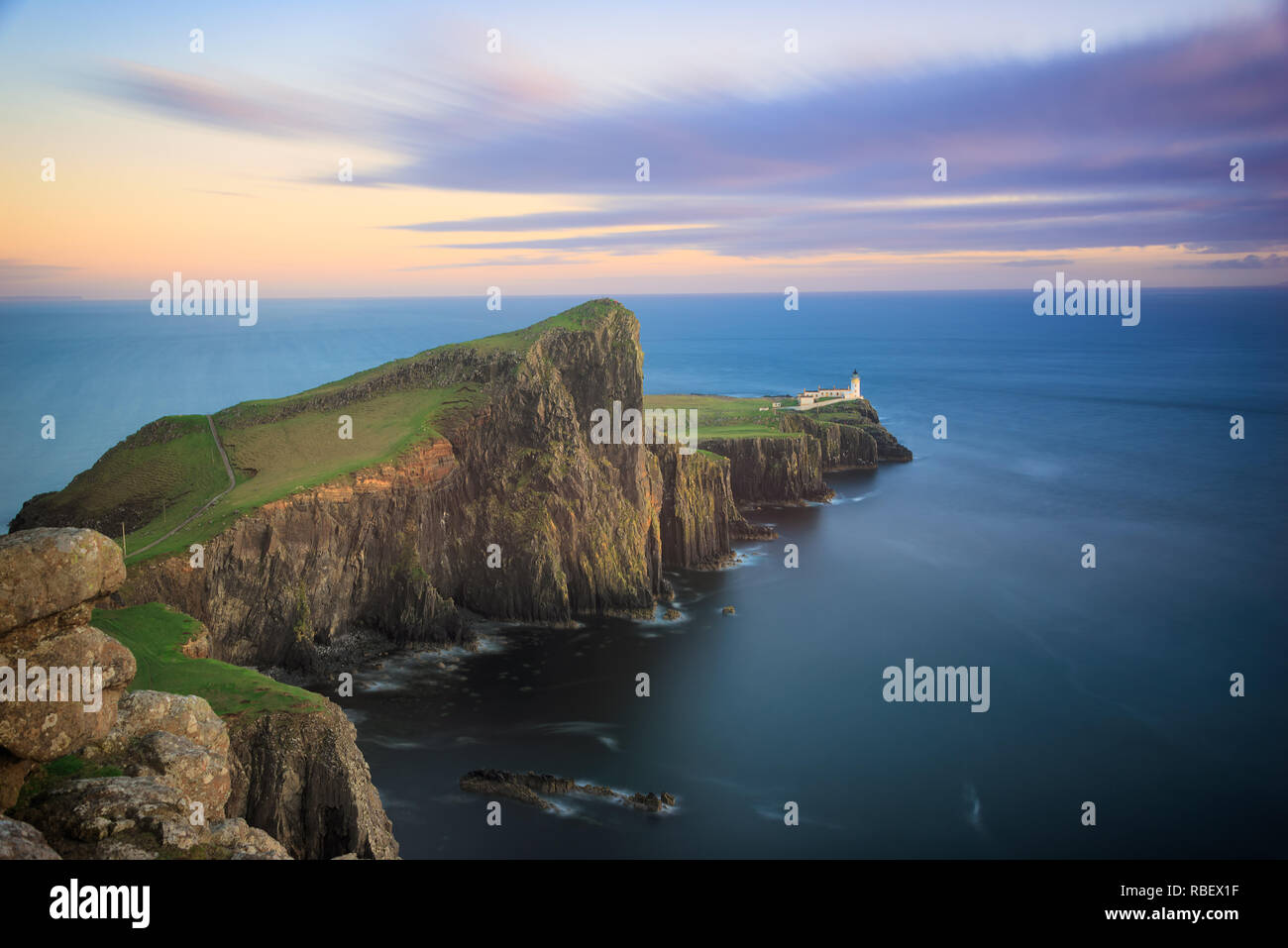 Neist Point Lighthouse costruita sulla scogliera alta sopra l'Oceano Atlantico sulla punta occidentale dell'isola di Skye in Scozia al tramonto. Foto Stock