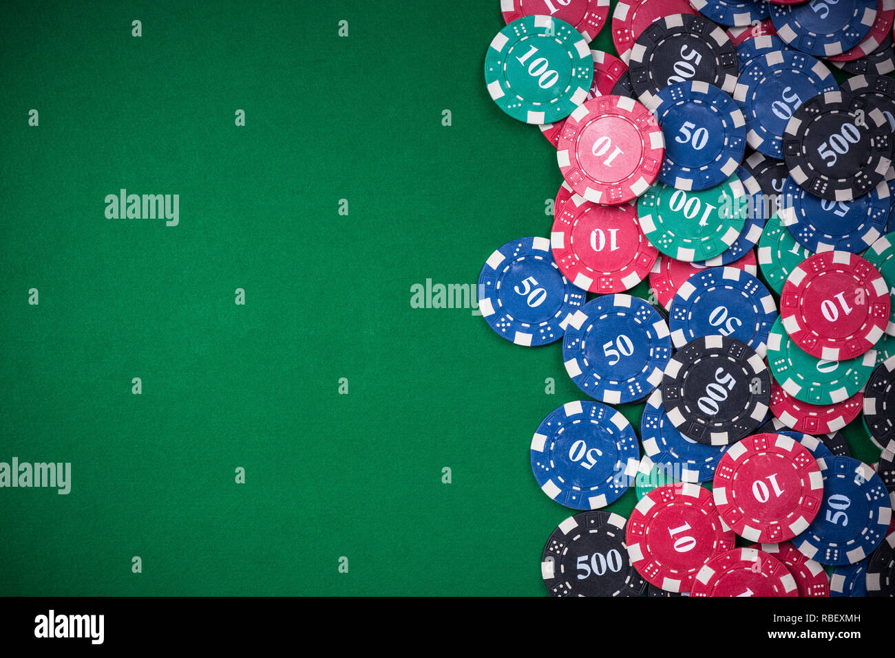 Poker chips sul green casino tavolo, sullo sfondo di confine. Foto Stock