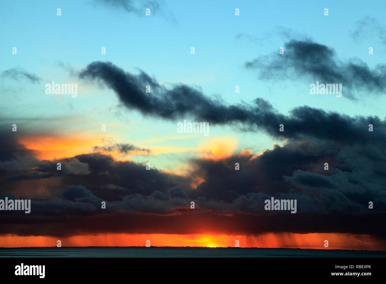 Sunset, rosso, blu, rosa, sky, nuvole nere, raccogliere tempesta, meteo, cieli, sky, formazione, formazioni, luce della sera, Norfolk, Inghilterra, Regno Unito Foto Stock