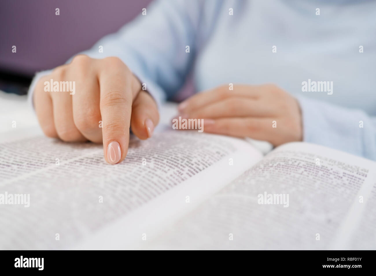 Studente nella biblioteca del college la preparazione per gli esami. Apprendimento, gratitudine, il concetto di religione. Irriconoscibile donna lettura big book - la Santa Bibbia e pregando. Christian studiare le scritture. Foto Stock