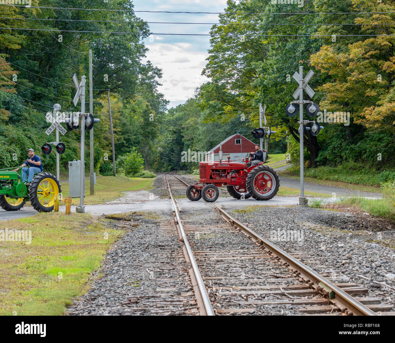 Un bel pomeriggio autunnale nella città del New England di New Milford, CT godendo di un antico trattore giro attraverso un vecchio ferroviarie per il trasporto merci. Deere farmall Foto Stock