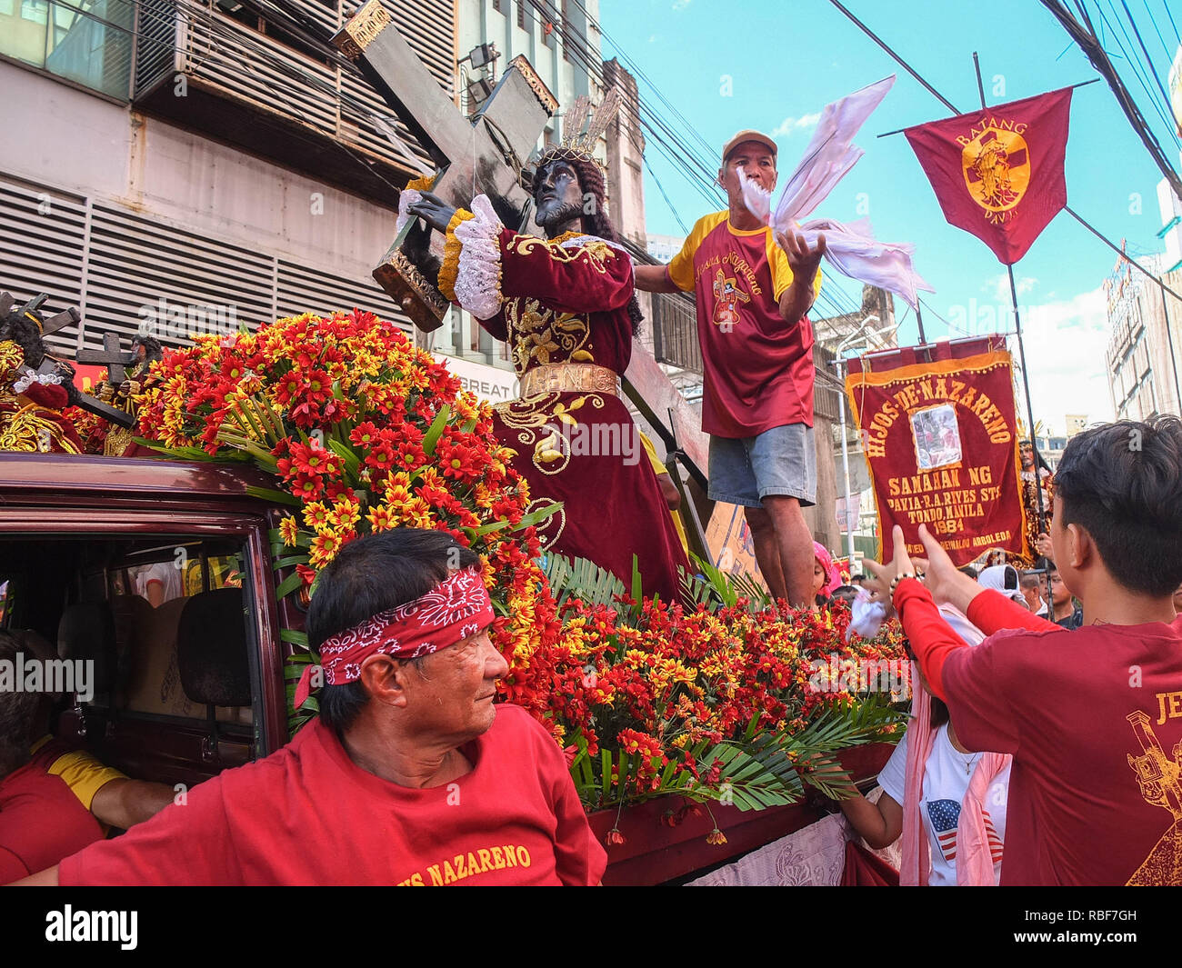 Manila, Filippine. Il 9 gennaio, 2019. Un devoto con il suo nero replica Nazareno, gettando indietro un asciugamano per un altro devoto durante la traslacion 2018 a Quiapo Chiesa.Traslacion, significa spostare un'immagine da un luogo ad un altro, si tratta di una pratica annuale osservata dall'Quiapo chiesa su di esso è sacro replica, il Nazareno nero. La replica sarà sfilavano da Quirino Grandstand di Quiapo Chiesa a Manila. Credito: Josefiel Rivera SOPA/images/ZUMA filo/Alamy Live News Foto Stock