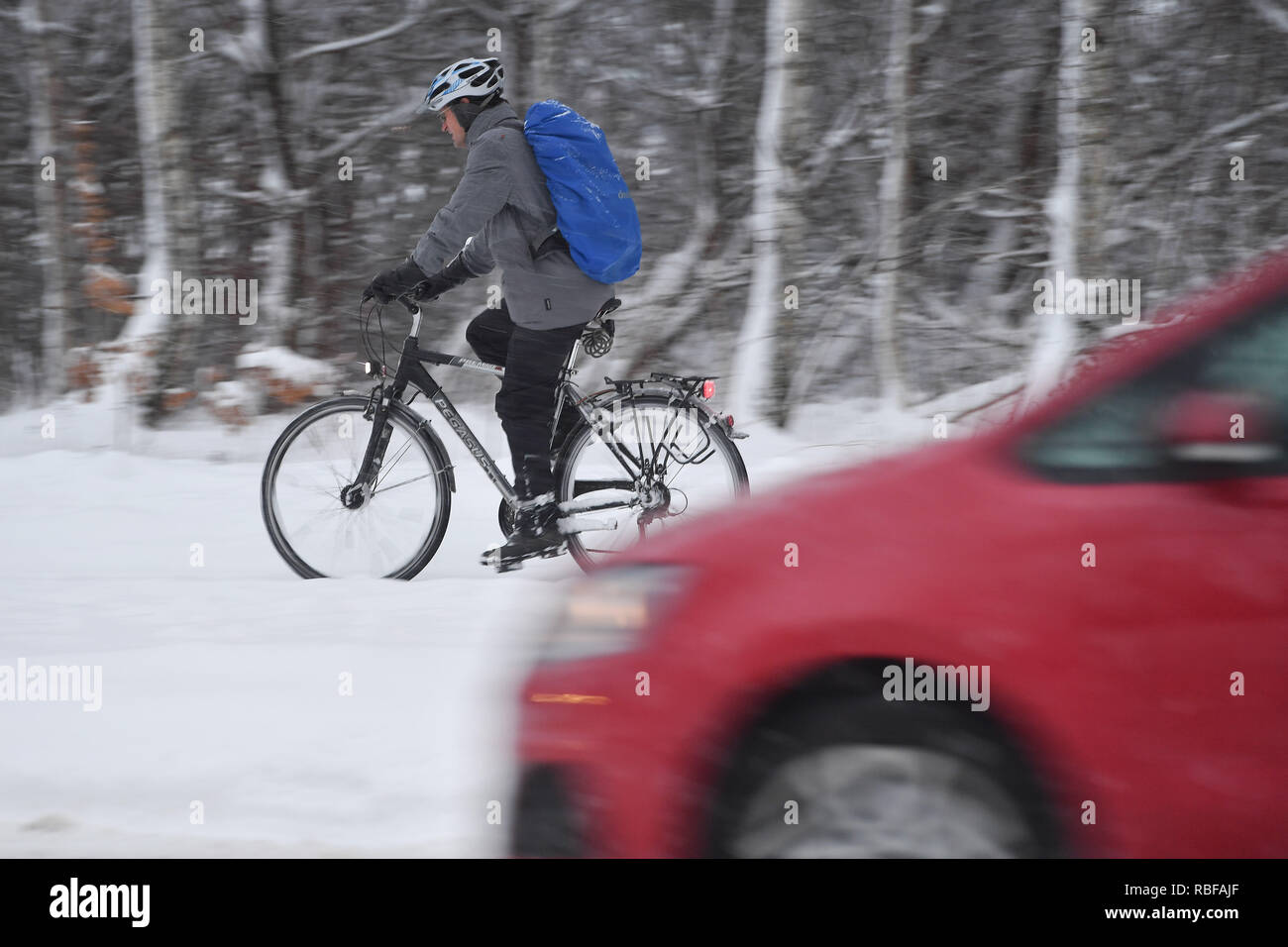 Monaco Riem, Deutschland. Decimo gen, 2019. Caos neve sulle strade della Baviera - come qui di Monaco Riem, il traffico dei pendolari, pendolari sulla neve-slick strade - probabilmente quello che proviene dalla bicicletta al suo luogo di lavoro, come questo ciclista. Auto, auto, PKSWs guida su un snowy .Strasse, il traffico automobilistico, il traffico stradale, continua nevicata su 10.01.2019, garantire neve caos traffico caotico, inverno in Baviera. | Utilizzo di credito in tutto il mondo: dpa/Alamy Live News/Alamy Live News Foto Stock