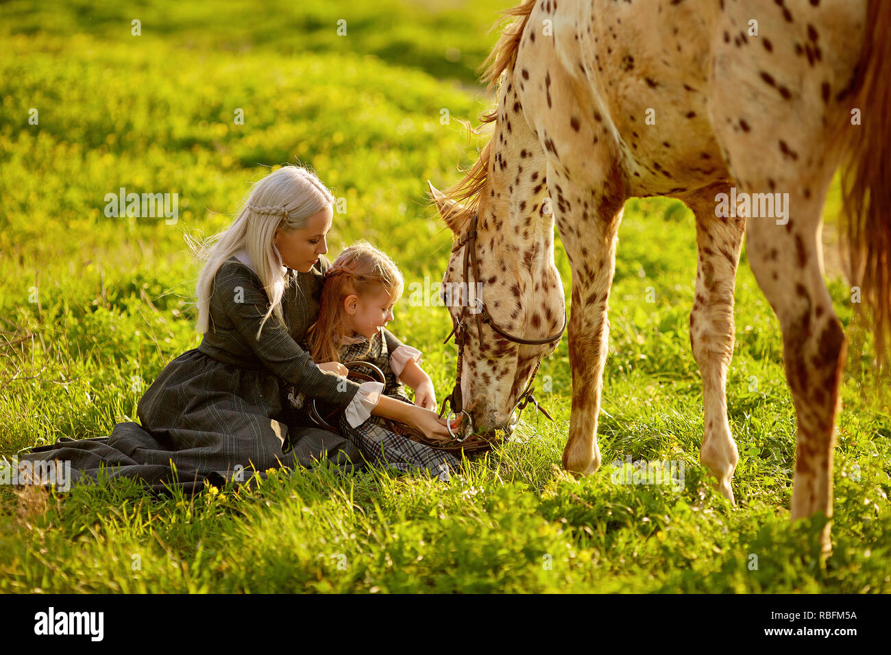 Bella donna e ragazza abbracciando cavallo Foto Stock