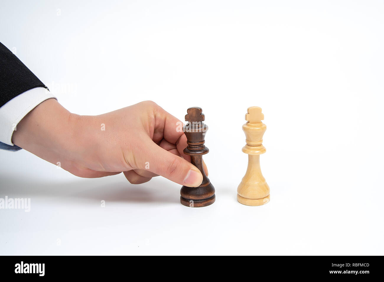 Mano di un imprenditore in movimento tenendo un re pezzo degli scacchi. Business il concetto di negoziazione Foto Stock