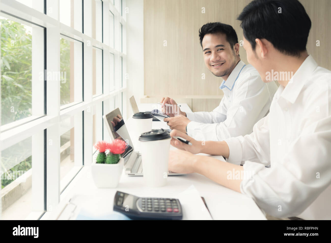 Due imprenditori asiatici in seduta cafe e discutere di affari progetto. Due dipendenti di sesso maschile consulting in cafe. Foto Stock