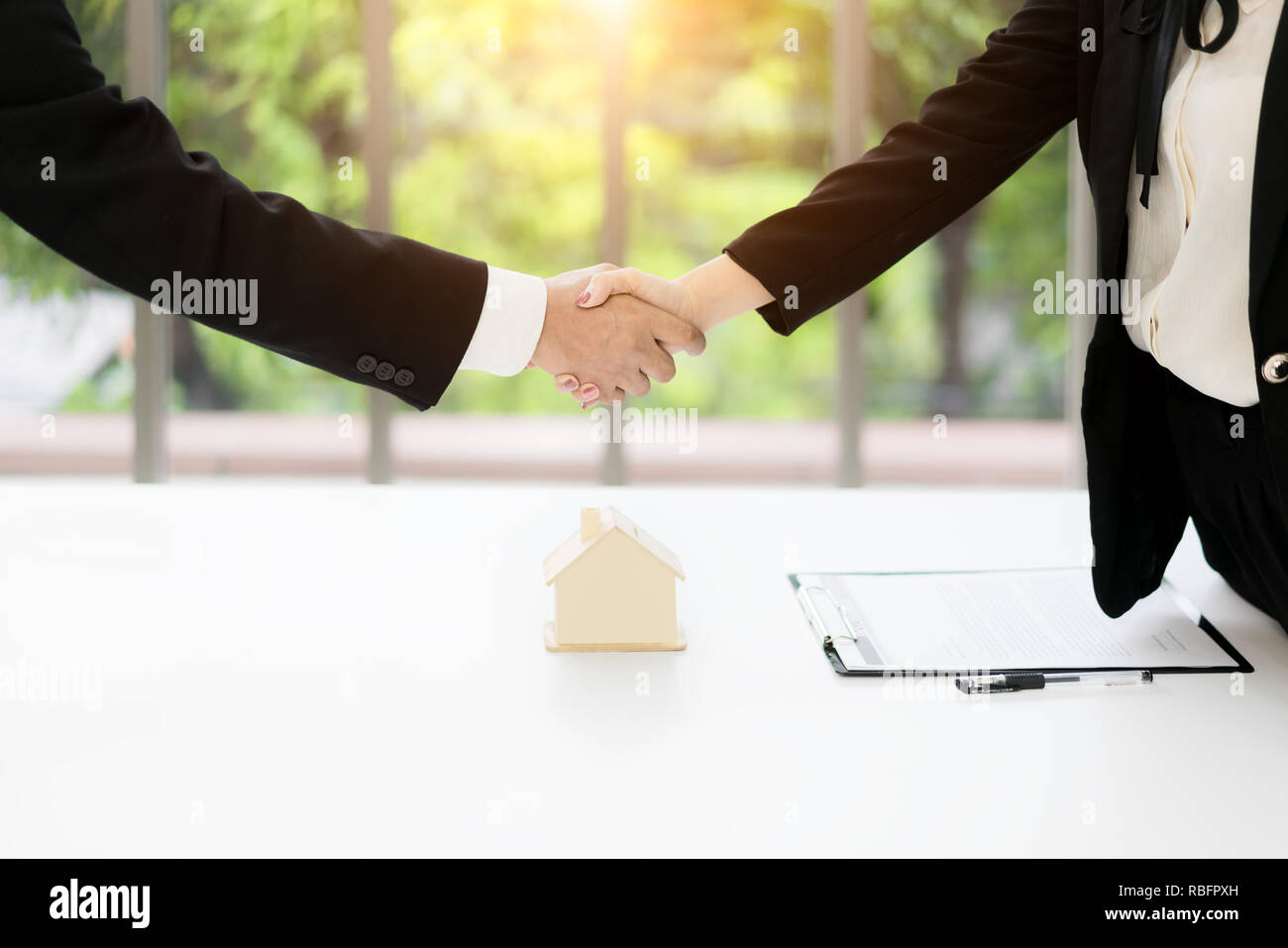 Agente immobiliare e il cliente si stringono la mano dopo la firma di un contratto: immobiliare, casa prestito e concetto di assicurazione Foto Stock