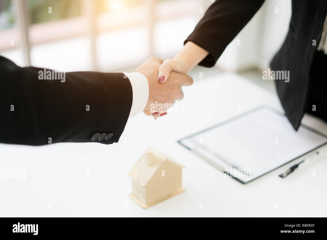Agente immobiliare e il cliente si stringono la mano dopo la firma di un contratto: immobiliare, casa prestito e concetto di assicurazione Foto Stock