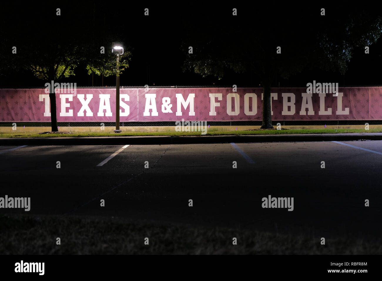 Texas A&M banner di calcio di notte lungo una catena collegamento recinto vicino a Kyle Campo sul campus della Texas A&M University College Station, Texas, Stati Uniti d'America. Foto Stock