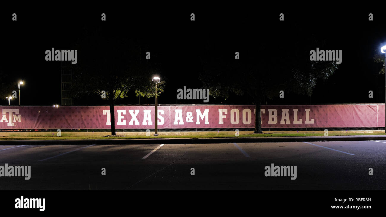 Texas A&M banner di calcio di notte lungo una catena collegamento recinto vicino a Kyle Campo sul campus della Texas A&M University College Station, Texas, Stati Uniti d'America. Foto Stock