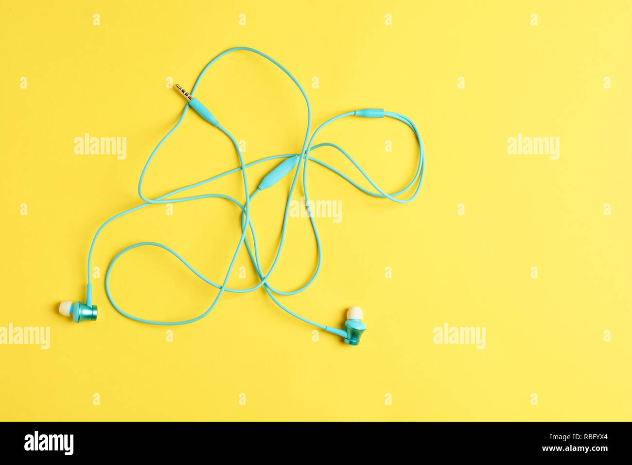 Piatto concetto laici: cuffie su sfondo giallo. Cuffie blu su sfondo giallo, vista dall'alto, copyspace. Alla moda foto colorate. Stile minimal con carta colorata sullo sfondo. Foto Stock