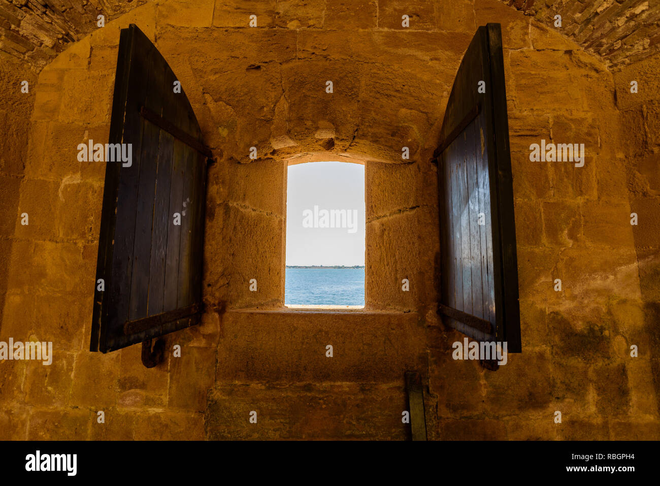 Aprire la finestra che si affaccia sul mare calmo e cielo blu con imbarcazioni di passaggio. Camera con vista sulla baia. Vacanza fronte mare soggiorno. Foto Stock