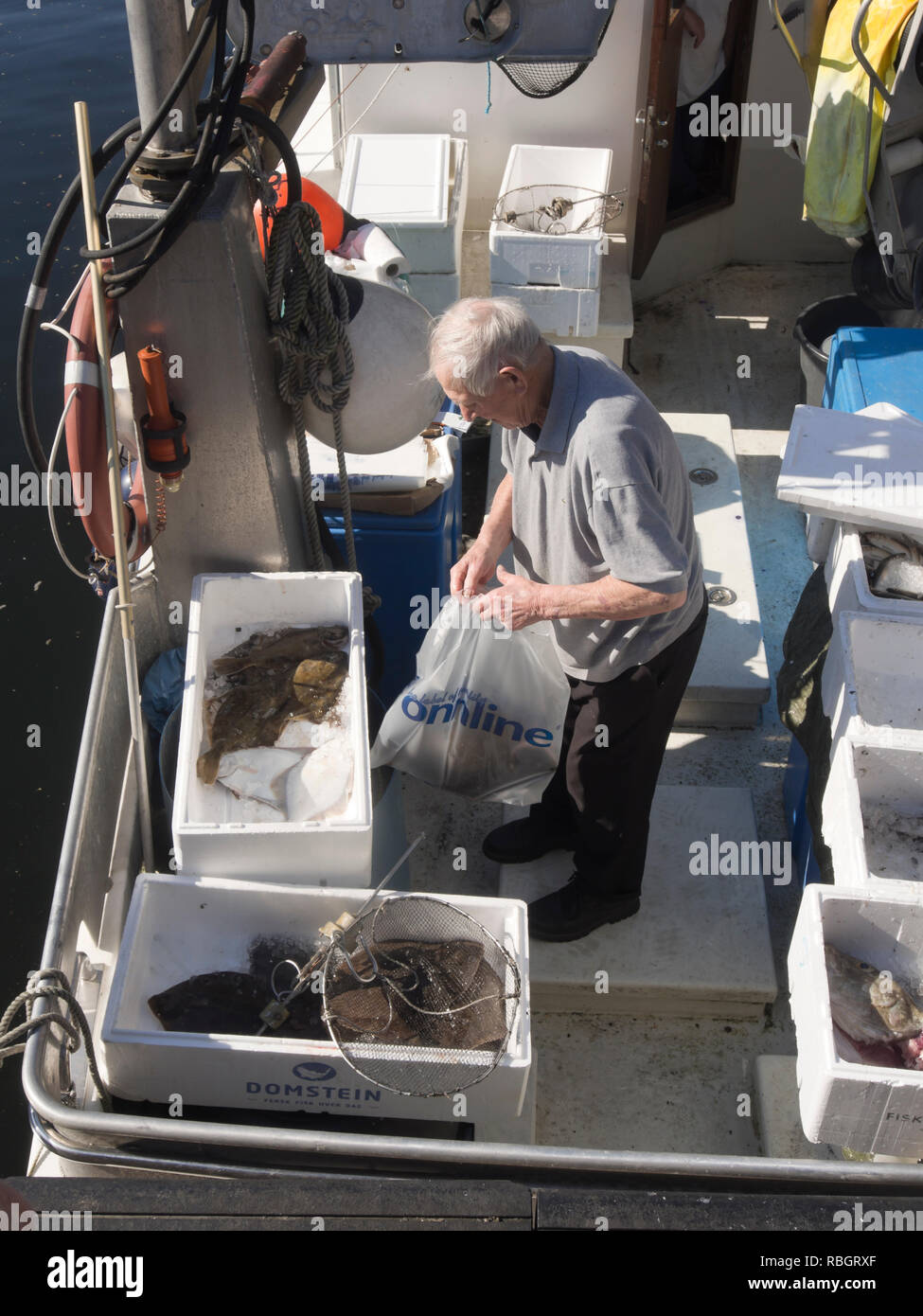 Pescatore locale nella sua barca vendere il pescato del giorno direttamente dal fiordo di Oslo nel porto centrale nella capitale norvegese Foto Stock
