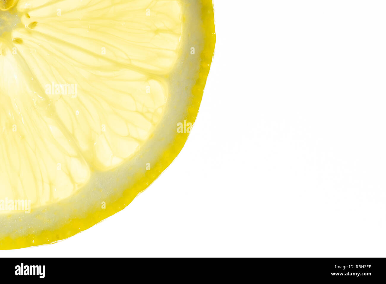 Fettina di limone close-up backlit su sfondo bianco Foto Stock