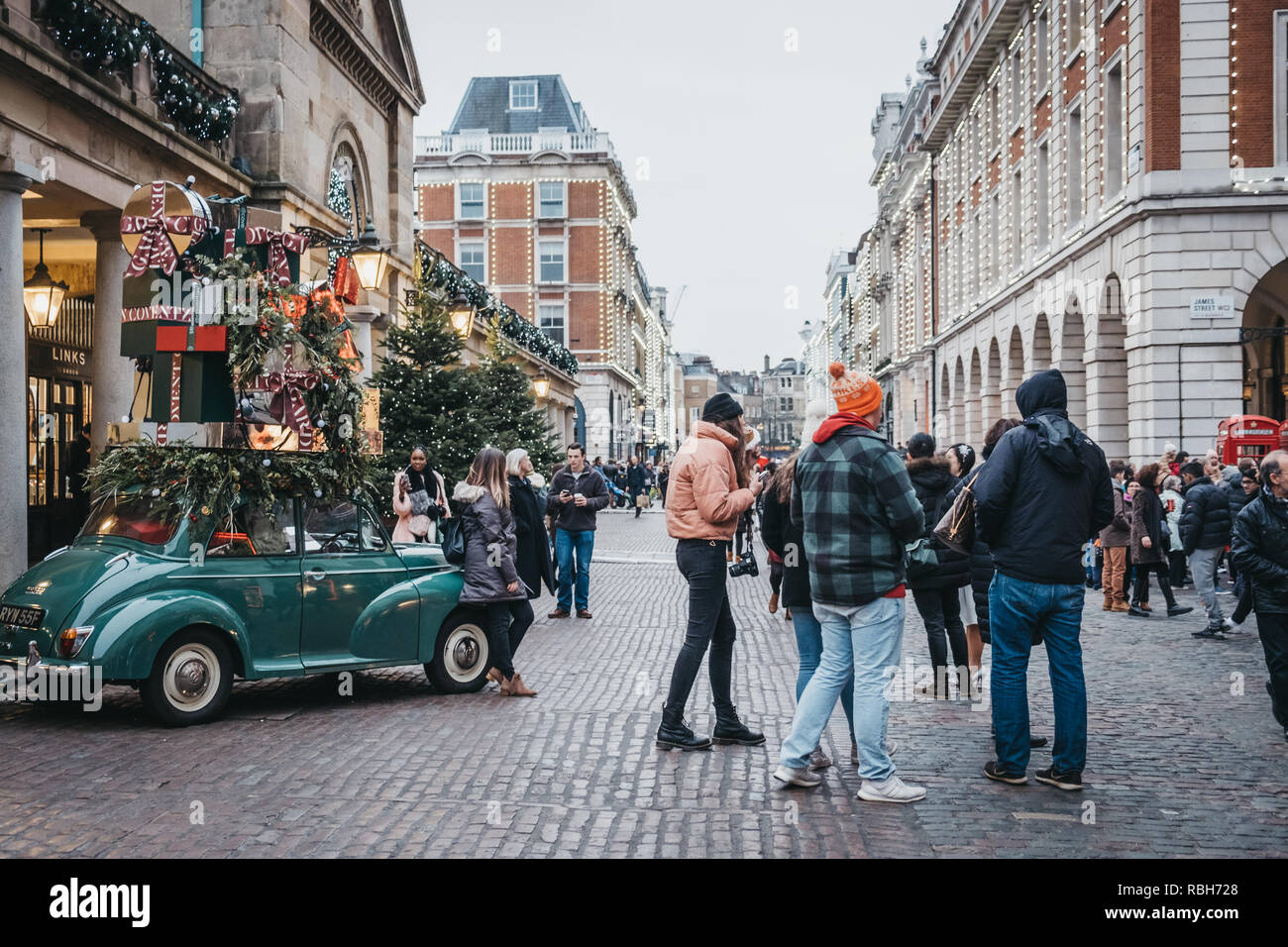 London, Regno Unito - 21 Novembre 2018: la gente camminare passato e scattare le foto di una vettura di decorazioni di Natale nel mercato di Covent Garden, uno dei più popolari Foto Stock