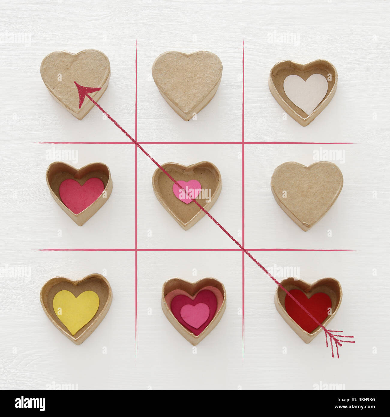 Il giorno di San Valentino concetto con carta scatole regalo come cuori. X-O GIOCO. Vista superiore in legno bakground bianco Foto Stock