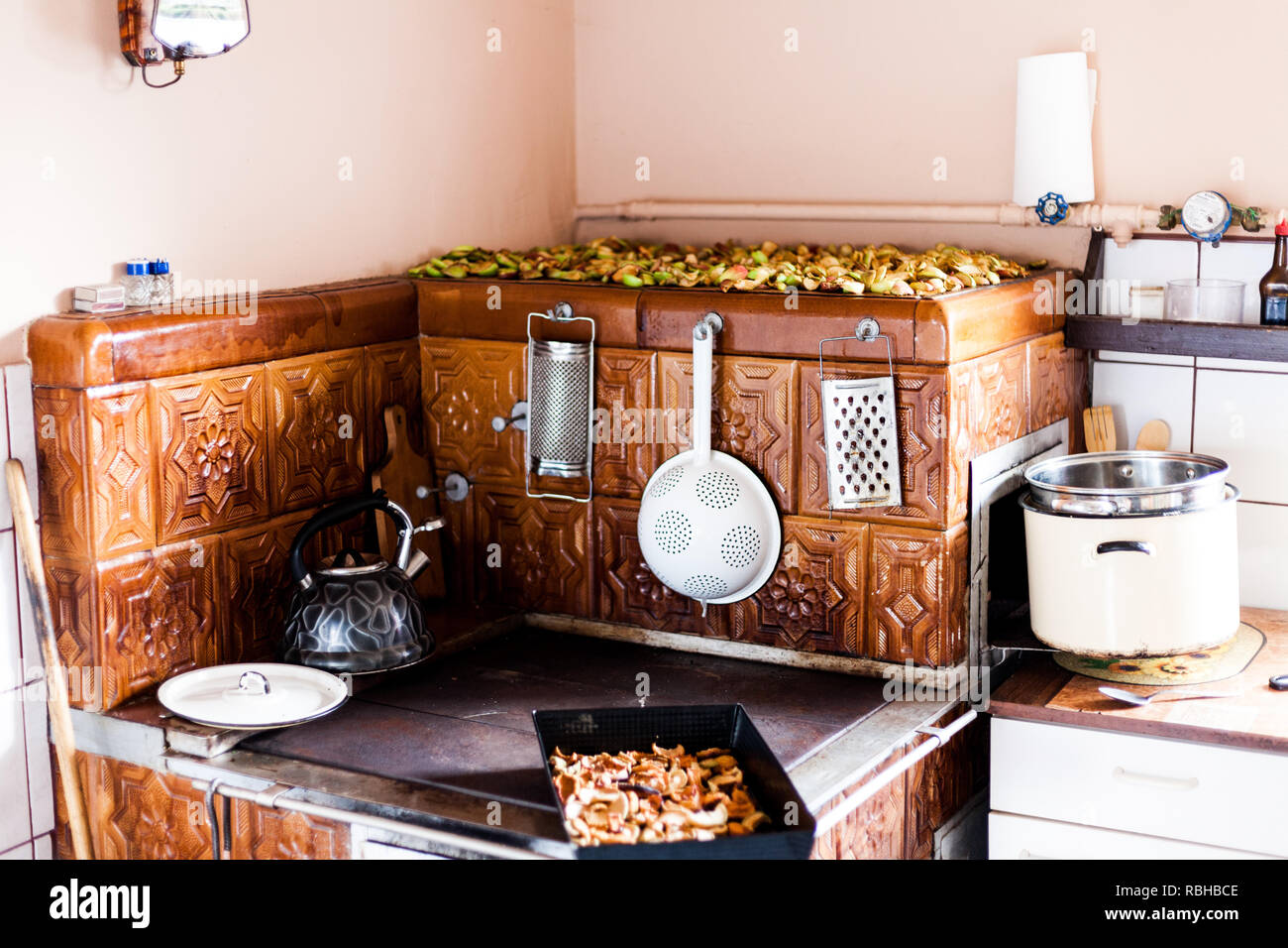 Il vecchio forno tradizionale con piastrelle in ceramica. Utensili da  cucina handeg sul vecchio forno. Cucina sulla vecchia maniera tradizionale.  Vecchia teiera sul fornello Foto stock - Alamy