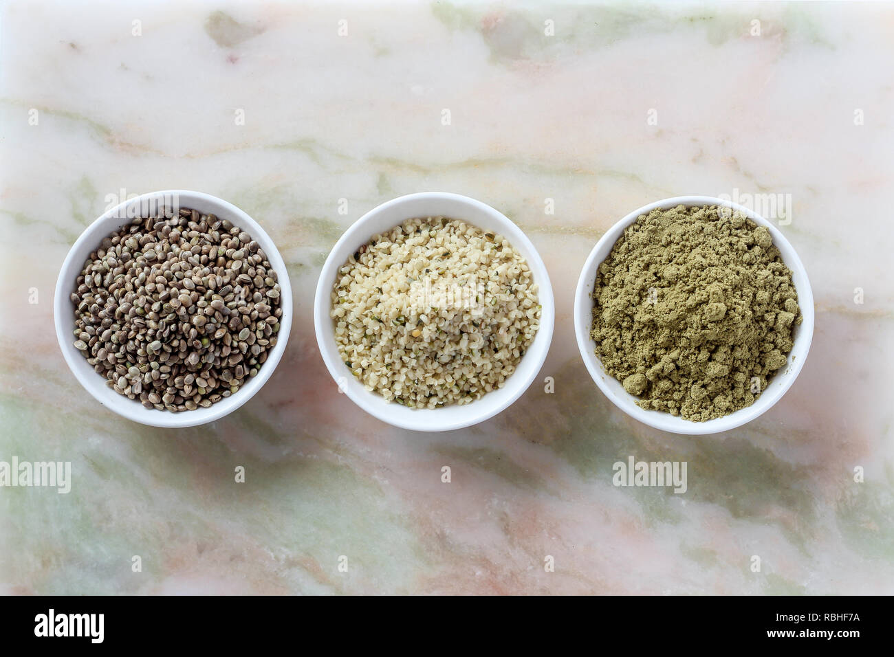 Organico tutta canapa semi, semi mondati e proteine in polvere in recipienti su un Sfondo marmo Foto Stock