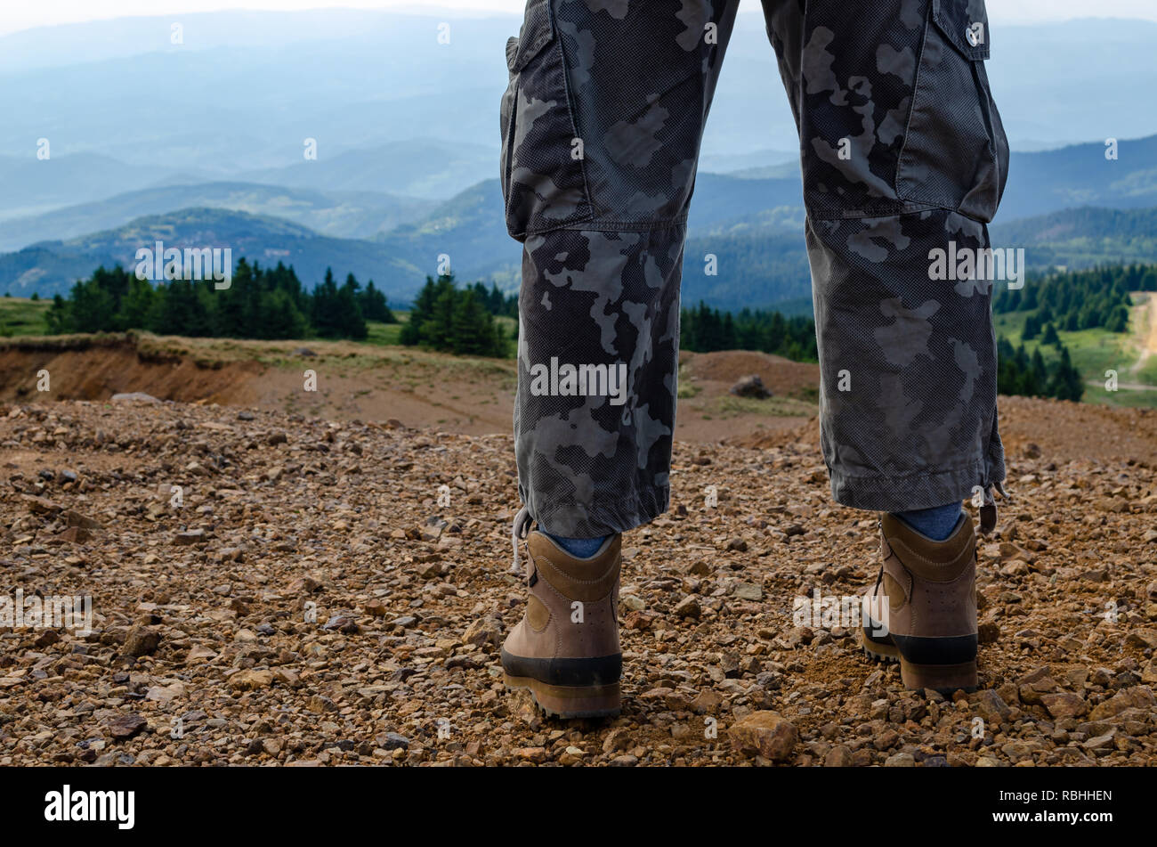 Uomo vestito per escursionismo in piedi sulla sommità del Kopaonik mountain, Serbia e guardare il paesaggio Foto Stock