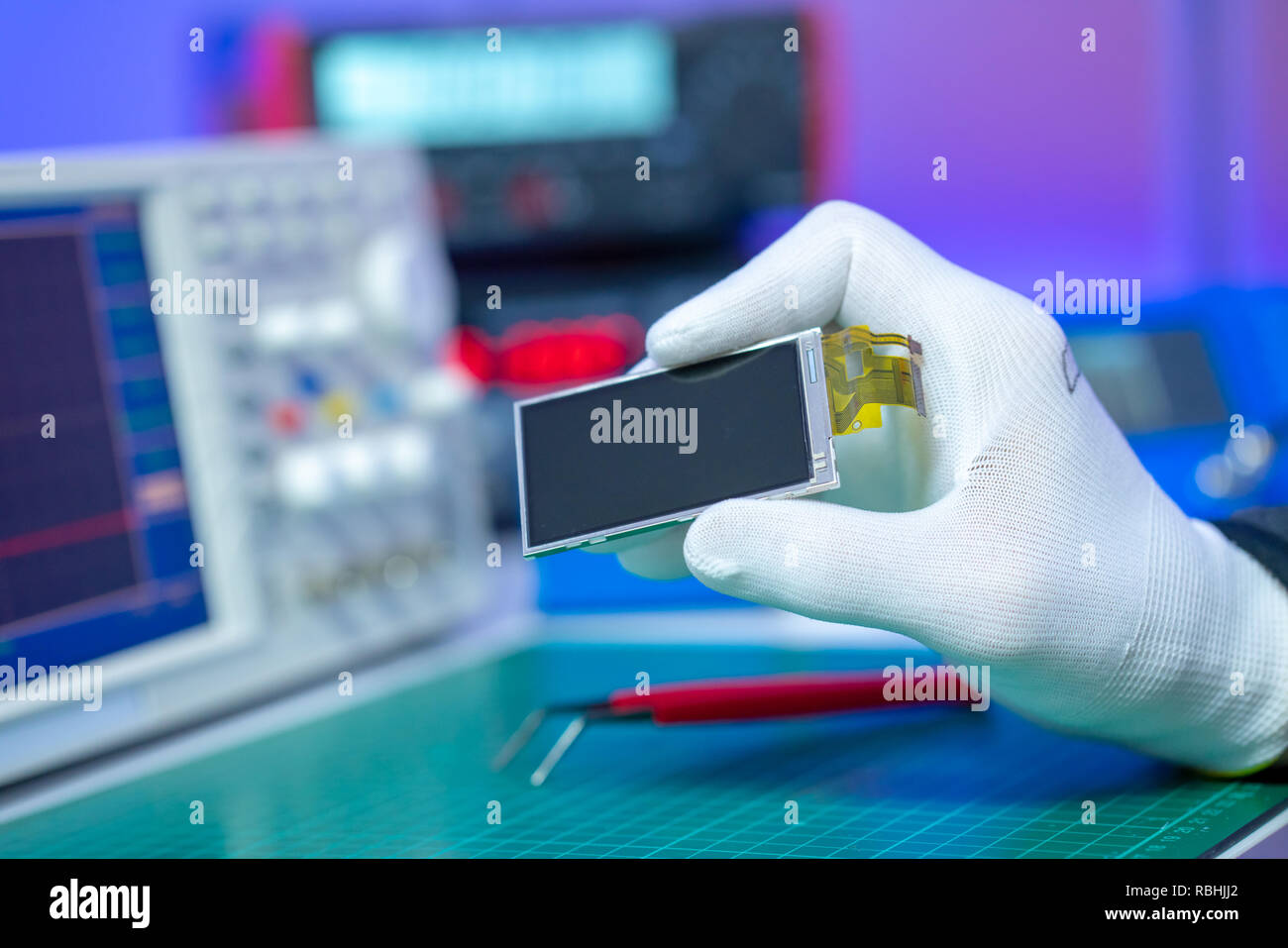 Tenere in mano il display di piccole dimensioni nel laboratorio di elettronica Foto Stock
