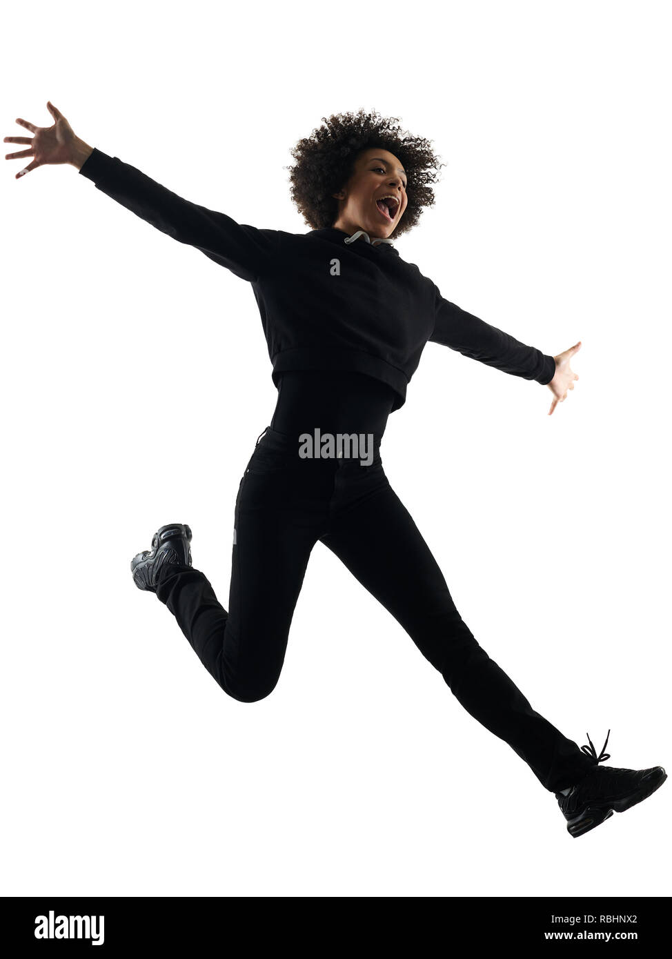 Una razza mista africana di adolescente Ragazza donna jumping happy in studio ombra silhouette isolati su sfondo bianco Foto Stock