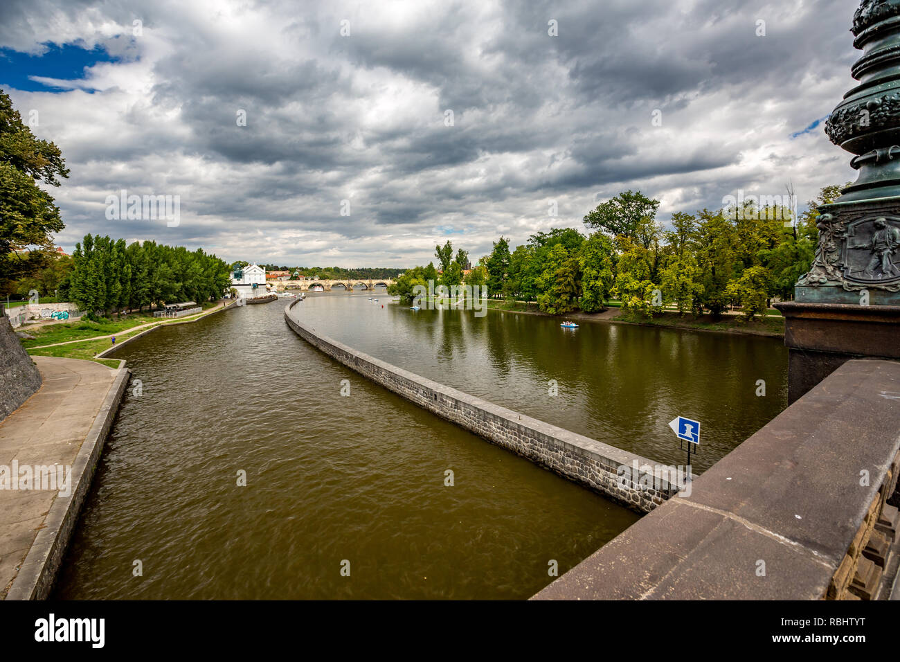 Acqua differenti livelli di trasporto vicino al cancello sul fiume Moldava a Praga, Repubblica Ceca. Drammatica nubi del cielo estivo nella capitale verde di alberi di pioppo su Foto Stock